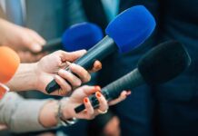 The Pentagon Remembers 184 Lives Reporters holding colorful microphones