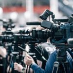 Governor Stunningly Dethroned — By His Own Party Broadcast cameras on tripods at a press event