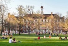 Two Deaths, One Mystery: Campus On Edge Students relaxing on a campus quad in front of a brick academic building
