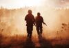 Marines Plan Thousands Of New Positions Two soldiers walking through a smoky field at sunset