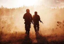 Marines Plan Thousands Of New Positions Two soldiers walking through a smoky field at sunset