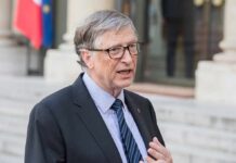 Bill Gates speaking outdoors in a suit and tie