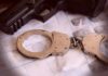 False Citizenship Claim Triggers Arrests Handcuffs on fingerprint sheets beside a handgun