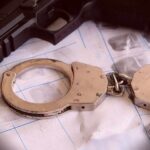 False Citizenship Claim Triggers Arrests Handcuffs on fingerprint sheets beside a handgun
