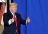 Trump’s Arch Goes Military? Donald Trump giving two thumbs up in front of a blue curtain