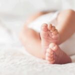 Massachusetts Baby Plan Triggers Trust War baby feet on a soft white blanket