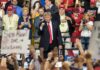 GOP Allies Put Affordability At Center Of Midterms politician on stage at a rally raising a fist amid cheering crowd