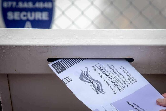 Mail-in ballot being inserted into a secure drop box slot