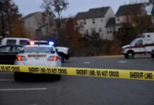 Sheriff's vehicles behind yellow do-not-cross tape