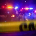 Rest-Stop Bloodbath Stuns I-80 Police cars with flashing lights behind yellow caution tape at night