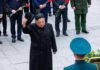 Satellite Clues Hint Explosive Expansion Man in black coat tipping hat during formal ceremony