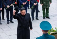 Satellite Clues Hint Explosive Expansion Man in black coat tipping hat during formal ceremony