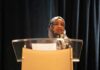 Republicans Bristle As Omar Recasts Billions Woman in hijab speaking at a podium
