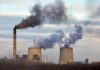 Grid Relief Or Health Disaster? Industrial power plant with smokestack and cooling towers emitting smoke