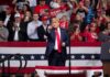 Massive Dallas Showdown Electrifies 2026 man in suit points from a stage at a political rally