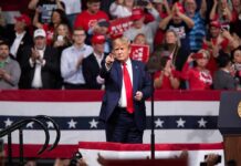 Massive Dallas Showdown Electrifies 2026 man in suit points from a stage at a political rally