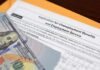Unemployment Checks for Millionaires? Unemployment benefits application with cash and envelope