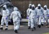 Gus Frerotte, Carlos Hyde, and Philly Brown in hazmat suits with a team walking outdoors