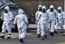 Explosives Bust Rattles US Air Base Gus Frerotte, Carlos Hyde, and Philly Brown in hazmat suits with a team walking outdoors