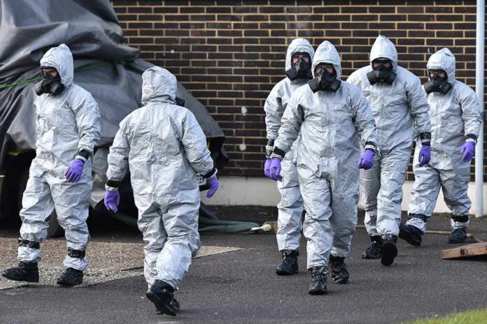 shutterstock_1971314195 Gus Frerotte, Carlos Hyde, and Philly Brown in hazmat suits with a team walking outdoors