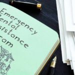 Public Funds Cushion ICE Sweeps Notebook titled Emergency Rental Assistance Program beside papers and pen