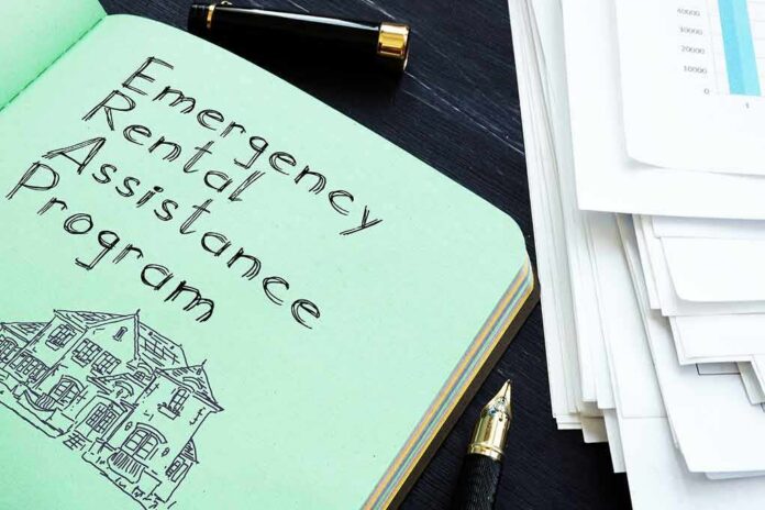 Notebook titled Emergency Rental Assistance Program beside papers and pen