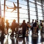 Five Years Later, Abbey Gate Questions Remain Passengers queue inside an airport terminal at sunset