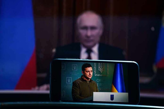 Vladimir Putin blurred in background behind smartphone showing a speech