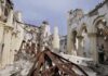 Interior view of a destroyed building with collapsed arches and debris