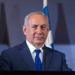 Empty Seats Humiliate Netanyahu man in suit at podium with microphones