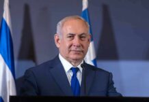 Empty Seats Humiliate Netanyahu man in suit at podium with microphones