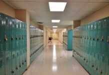 Whistleblower Claims Rigged Credits School hallway with rows of teal lockers