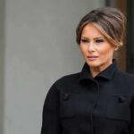Melania Trump in a black coat looking to the side