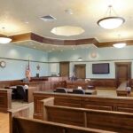 Tourist Nightmare: Triple-Murder Plot Exposed Empty courtroom with wooden benches and judge's bench