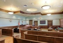 Tourist Nightmare: Triple-Murder Plot Exposed Empty courtroom with wooden benches and judge's bench