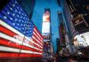Legal Heat Builds Over Patriotic Ads American flag LED display in Times Square at dusk