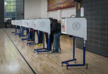 405 Ballots Flagged By DOJ Voters at polling booths in a gymnasium