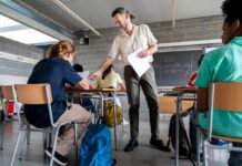 State Takeover Looms at LA Schools Teacher handing out papers in a classroom