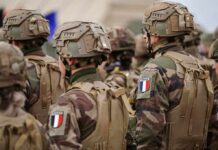 Prime Minister Hesitates As France Burns Soldiers in camouflage uniforms wearing helmets and body armor