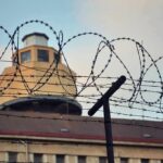 Pentagon Confirms First Execution in Decades Barbed wire fence in front of a prison watchtower