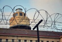 Pentagon Confirms First Execution in Decades Barbed wire fence in front of a prison watchtower