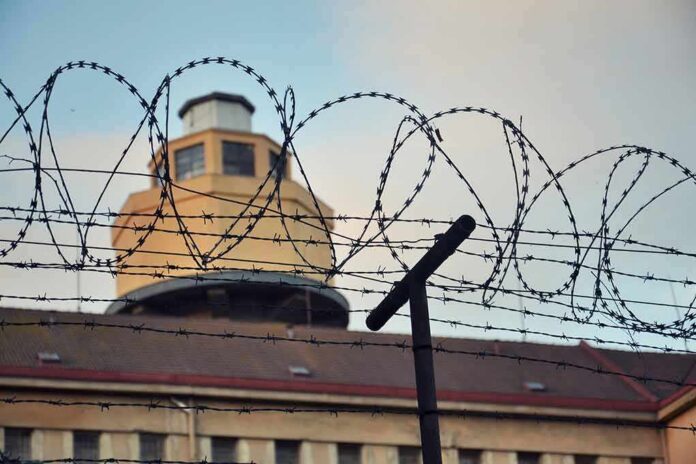 Barbed wire fence in front of a prison watchtower