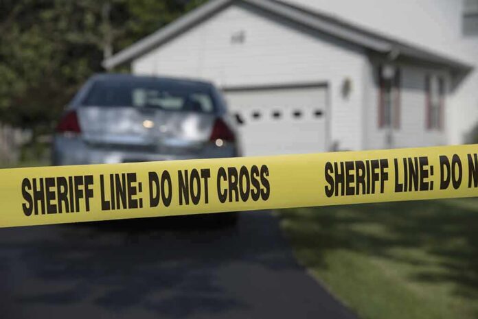 Sheriff line tape blocking a suburban driveway