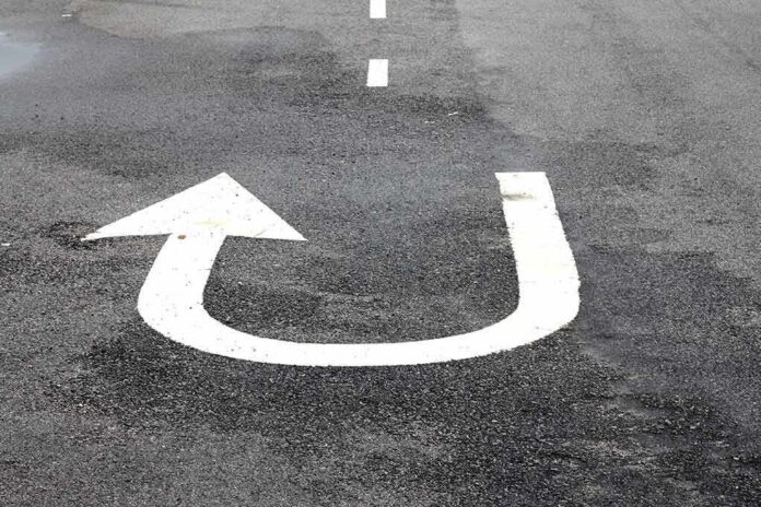shutterstock_528097312 U-turn arrow painted on asphalt road