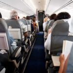 Airplane cabin with passengers seated in rows
