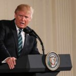 Never Forget: Trump’s Hardline Message Donald Trump speaking at a podium with presidential seal
