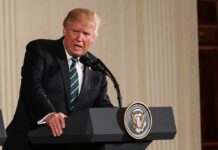 Never Forget: Trump’s Hardline Message Donald Trump speaking at a podium with presidential seal