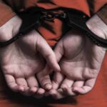 Public Execution Shock From Pentagon person in handcuffs with hands behind back